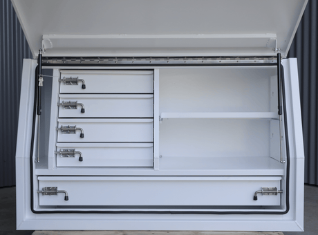 Australian Performance Boxes white 1400mm gullwing toolbox with five drawers, angled view in a warehouse setting.