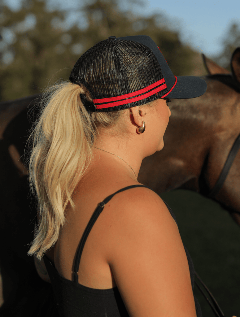 Woman with ponytail wearing the apboxes navy trucker hat