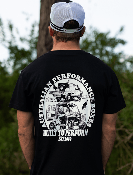 Man with back facing wearing a Black Australian Performance Boxes Built To Perform T-shirt showing an illustration.