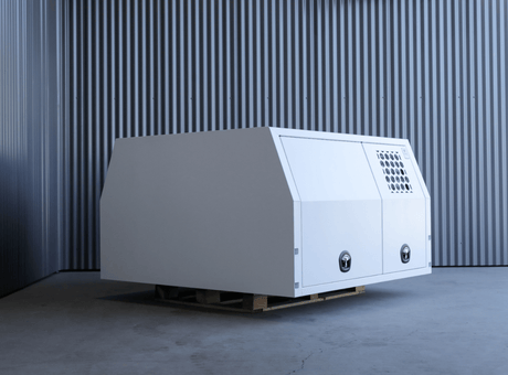 Apboxes LC79 1700mm full dog box canopy in white, rear and side view sat on a warehouse floor.